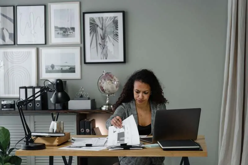 Documents de facturation classés, tableau de suivi et tampon payé sur un bureau clair